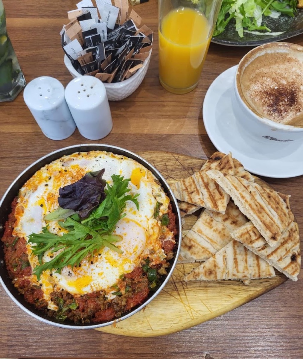Afghan-style shakshuka with bread, cappuccino and orange juice at Kessa